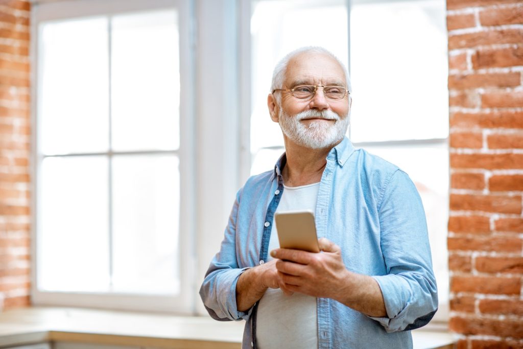 Senior man with phone at home