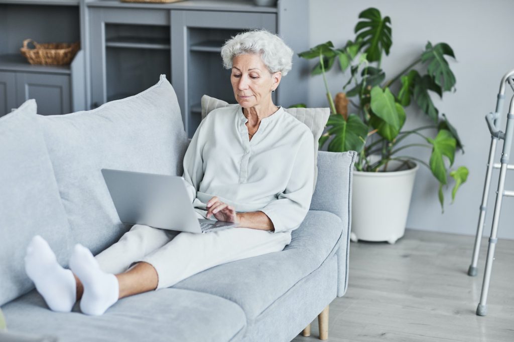 Senior Woman Using Laptop on Couch